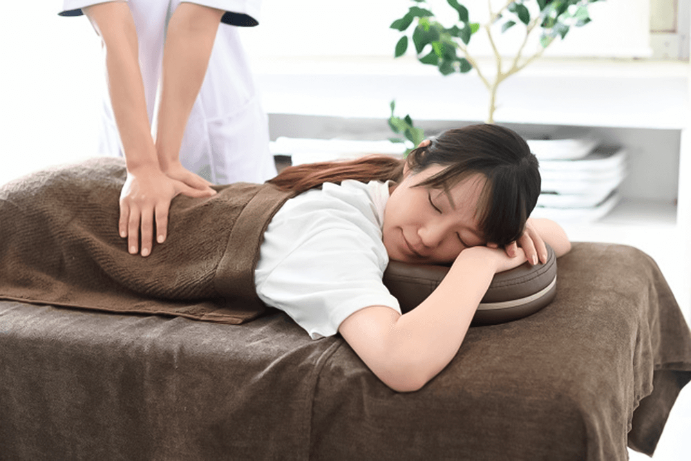 男性トレーナーに指導されてピラティスをしている女性の画像